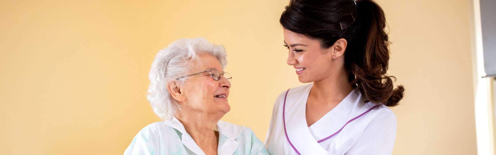 caregiver and elderly woman wearing glasses