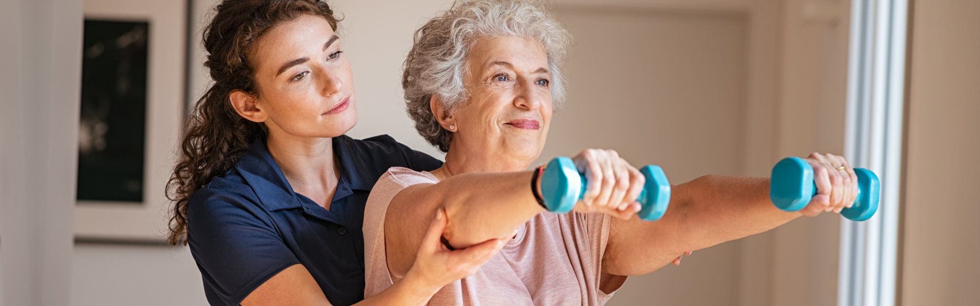 caregiver assisting the senior woman do some exercise