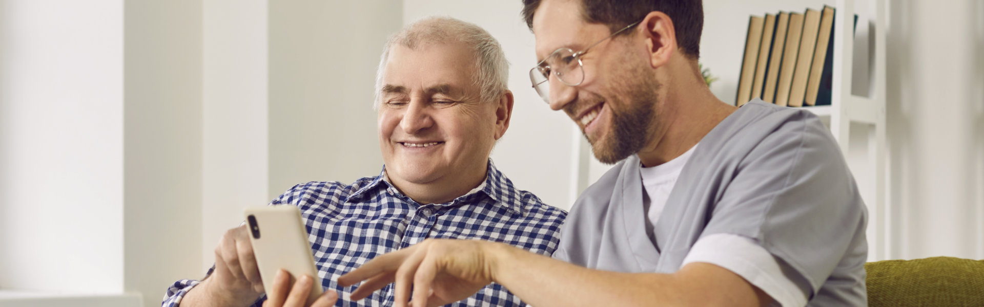 senior man and his caregiver using the phone