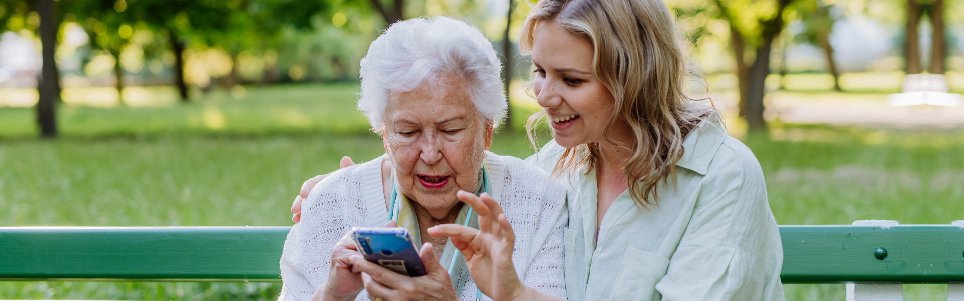 caregiver and senior woman looking at the phone