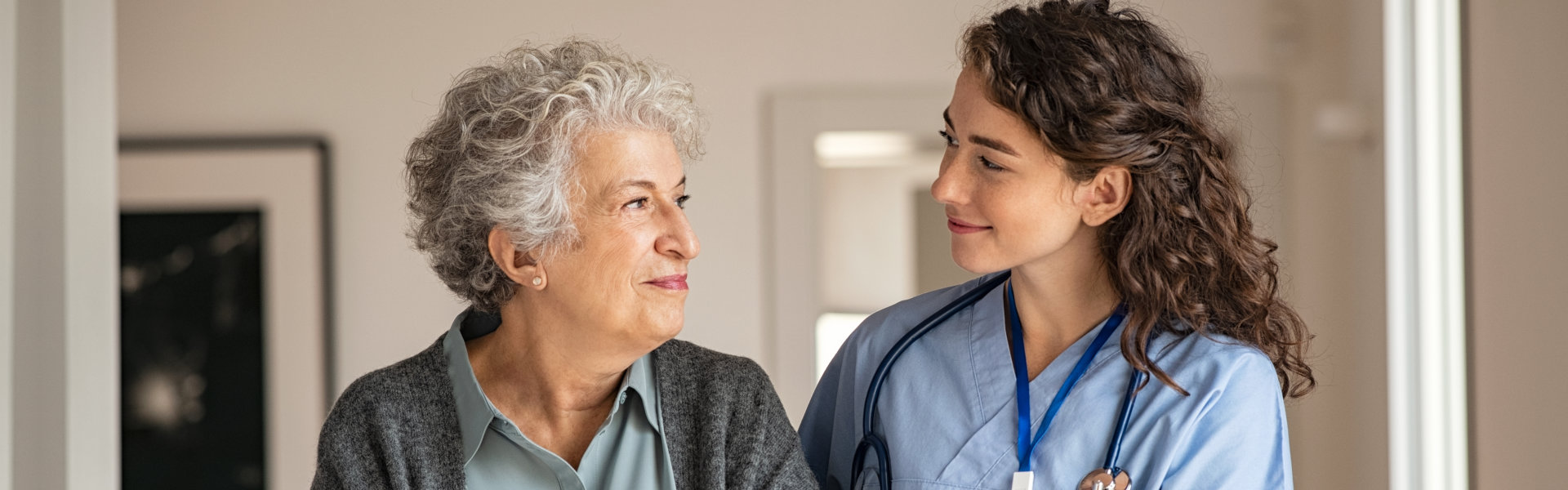 nurse and senior woman walking in the hallway