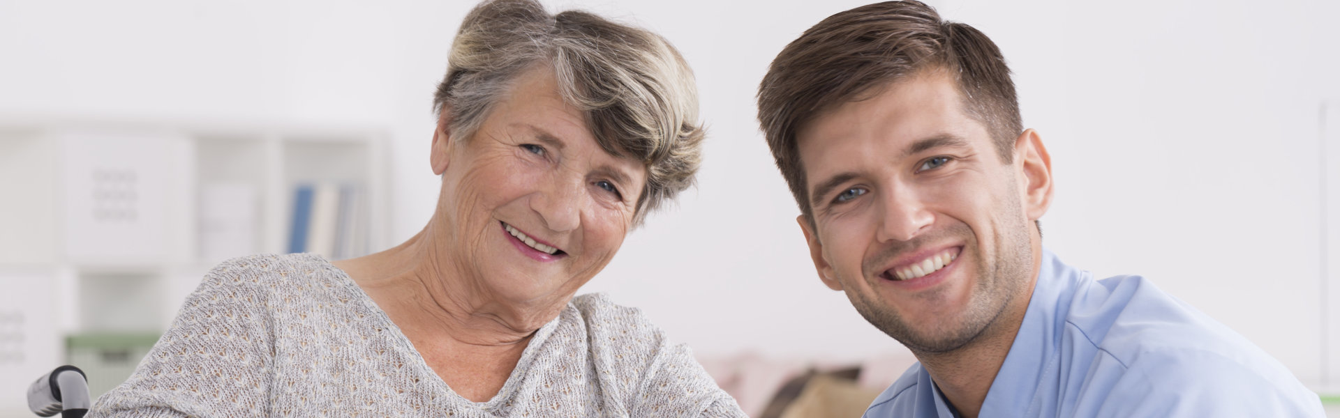 male caregiver and senior woman smiling